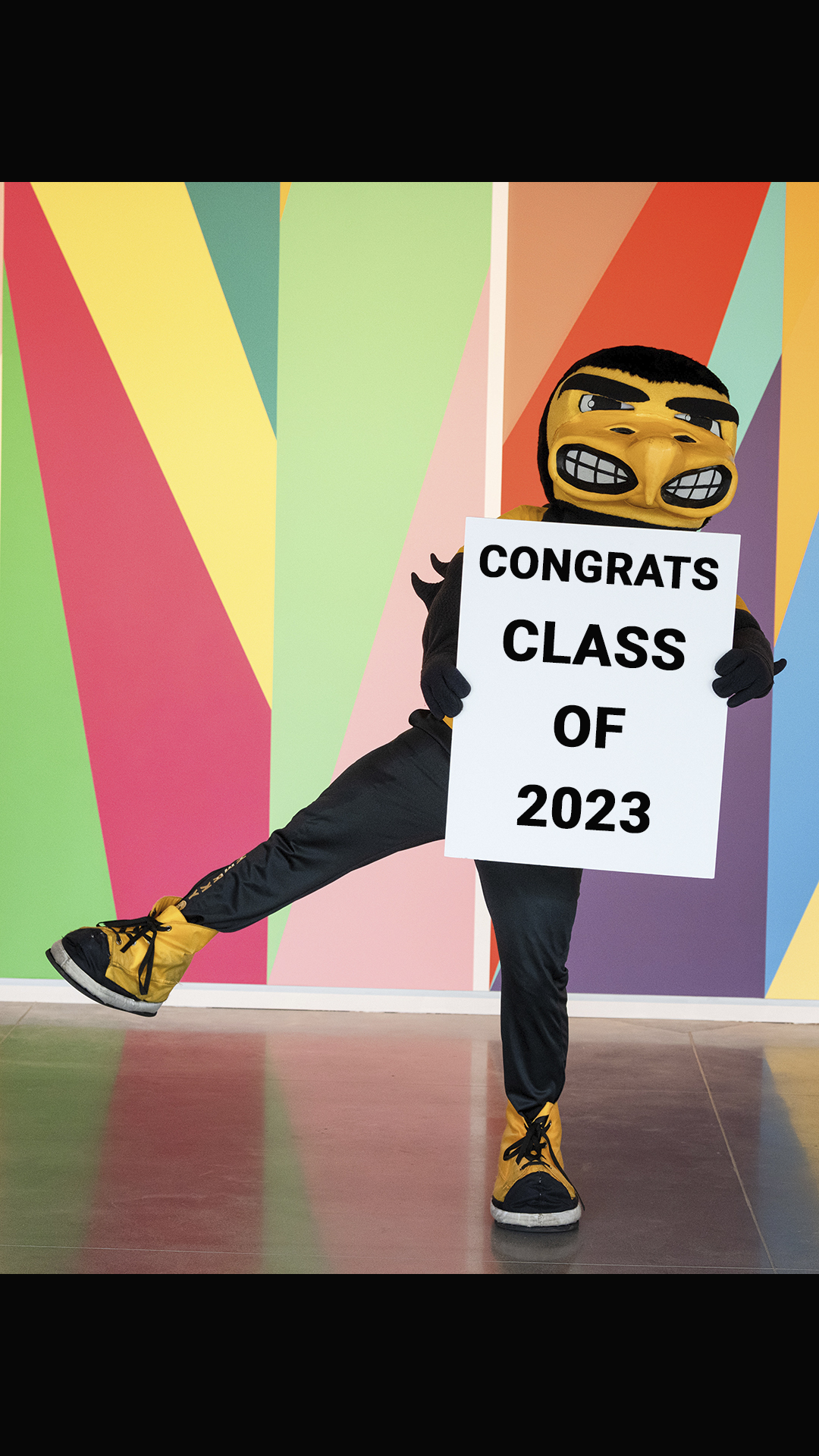 Herky holds a sign saying "congrats class of 2023"