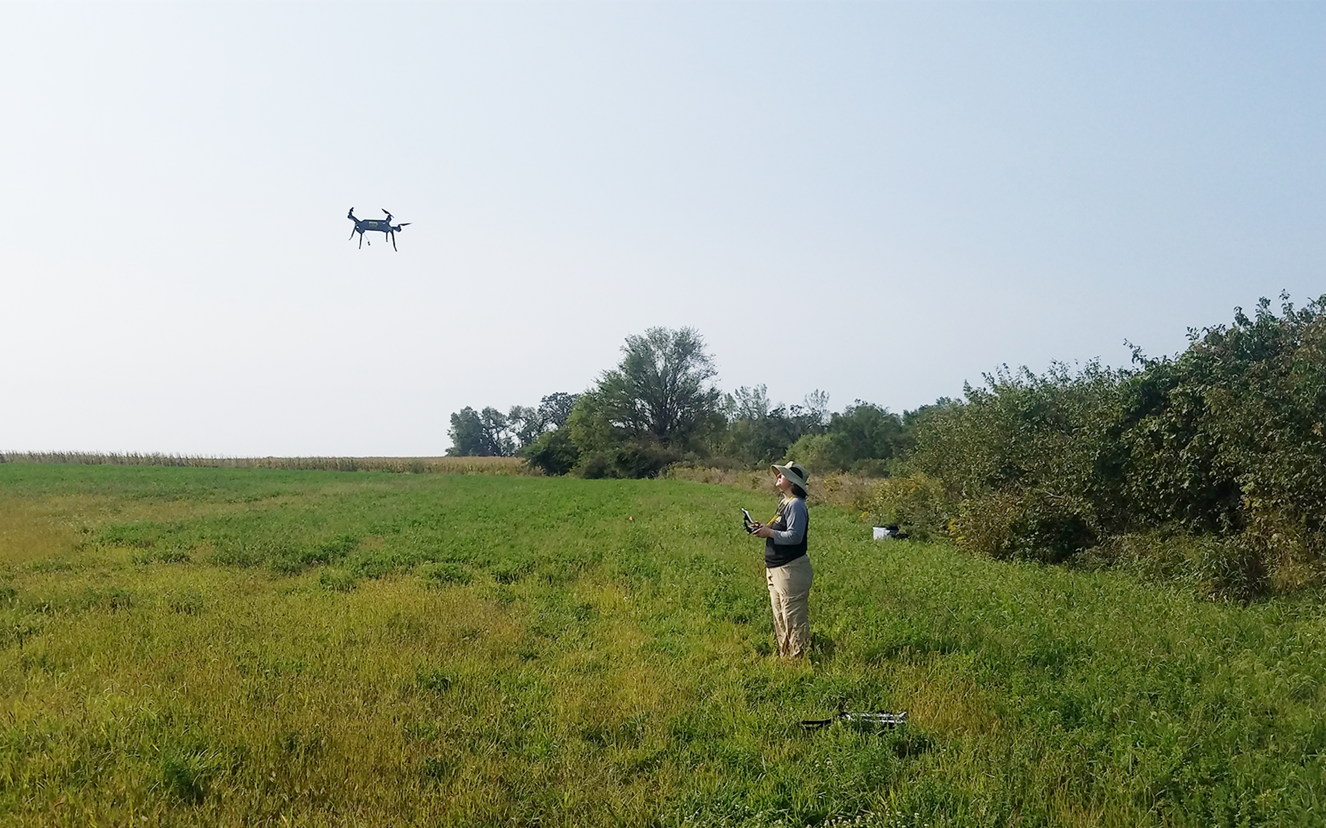 Women flying a drone in an open field