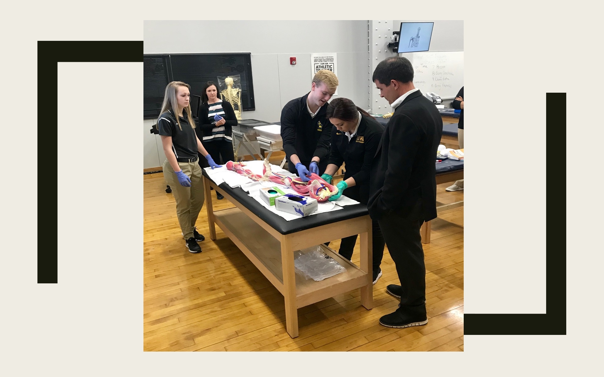3 students looking at anatomical models in the athletic training lab